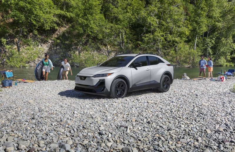 A static image of Uncharted Sport in Metropolis Gray Metallic parked on a rocky bank of a river.