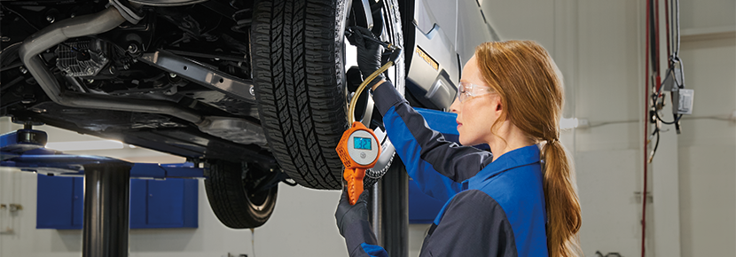 A Subaru technician checking tire pressure. | Santa Monica Subaru in Santa Monica CA
